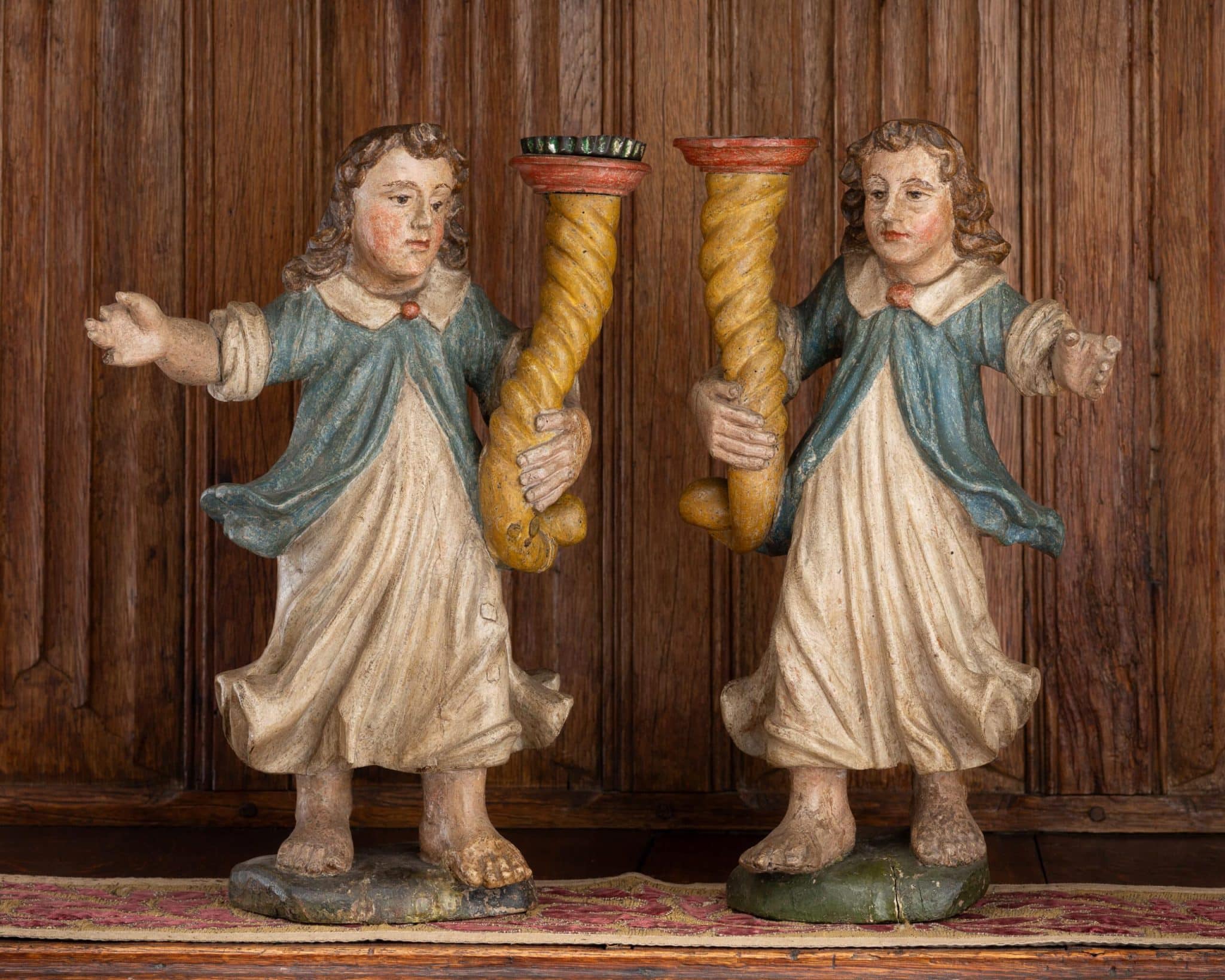 Pair of Polychromed Oak Figures Holding Cornucopia-Form Candleholders